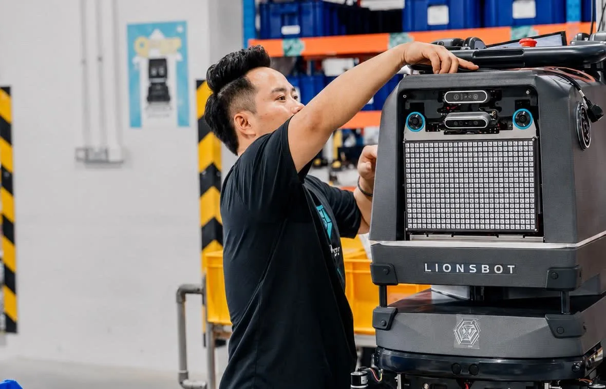 A LionsBot engineer working on a robot on the Singapore assembly floor