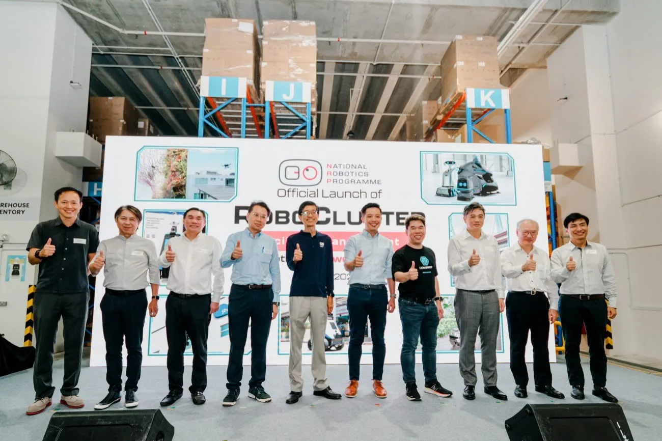 Ten representatives from LionsBot and partner organisations standing on stage in front of a backdrop reading Official Launch of RoboCluster, National Robotics Programme