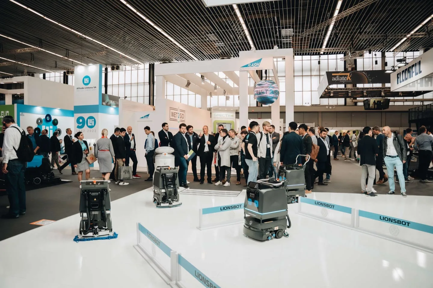 Visitors crowded around the LionsBot stand at Interclean Amsterdam 2022 watching a live demonstration
