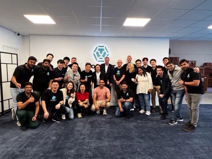 A large group photograph of the LionsBot team standing and kneeling in front of a wall bearing the LionsBot emblem