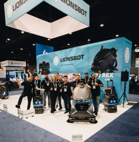 The LionsBot team celebrating at their stand at the ISSA Show North America in Chicago