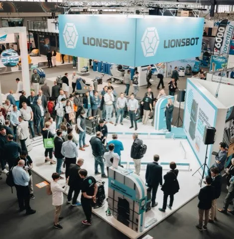 A crowd gathered around the LionsBot stand at Interclean Amsterdam 2022, seen from above