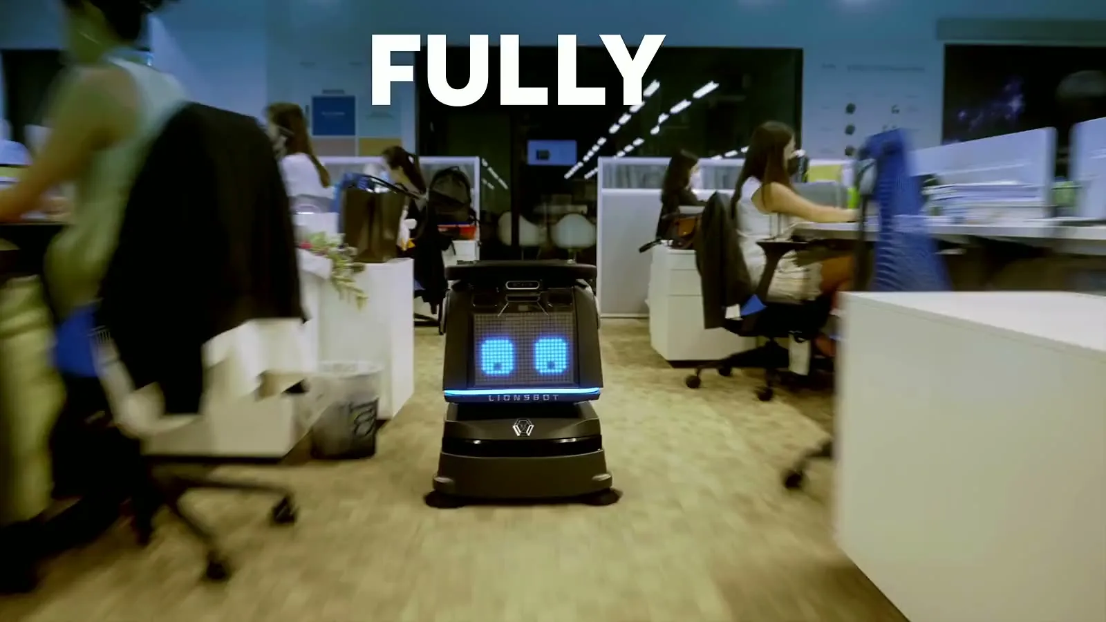 A LionsBot R3 Vac running on its own down an office aisle, then a cleaner taking its handle to vacuum by hand